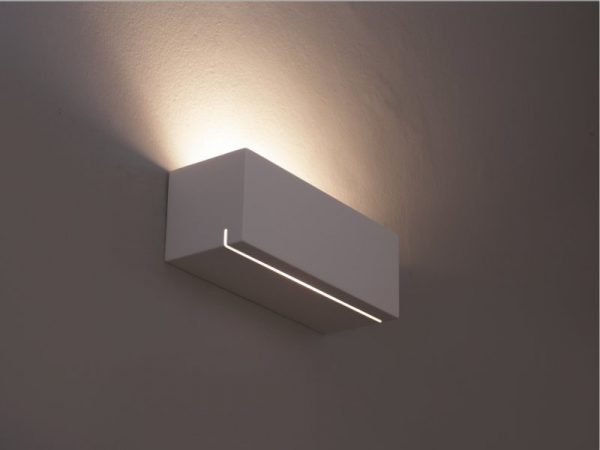 The Cleoni Belle Ang Wall Light features a rectangular design in a ceramic white finish, with slit in the bottom of the fitting to allow bidirectional ambient lighting.