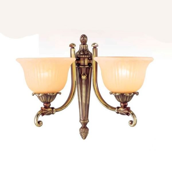 The Riperlamp Bologna Wall Light features a traditional design with two floral inspired acid amber glass lampholders. Each lampholder is supported by a curved metal arm attached to a metal base in bronze finish.