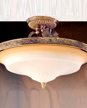 The Riperlamp Esparta Ceiling Light features a curved amber glass diffuser and bronze metal base with repeating floral motifs.