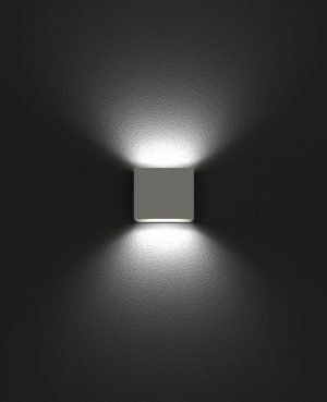 The Cleoni Kubik Wall Light features a cube shaped design with bidirectional ambient lighting in a ceramic white finish.