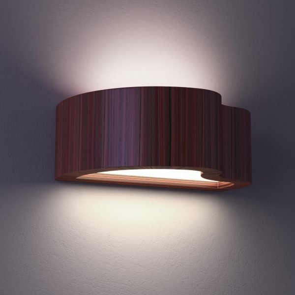The Cleoni Atego Wall Light, featuring an abstract, curved design in a wooden finish with bidirectional lighting, is shown turned on in a darkened room.